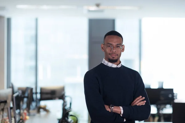 L'uomo afroamericano guarda la telecamera in piedi nell'atrio dell'ufficio. Ritratto del team di manager aziendali multiculturali. — Foto Stock