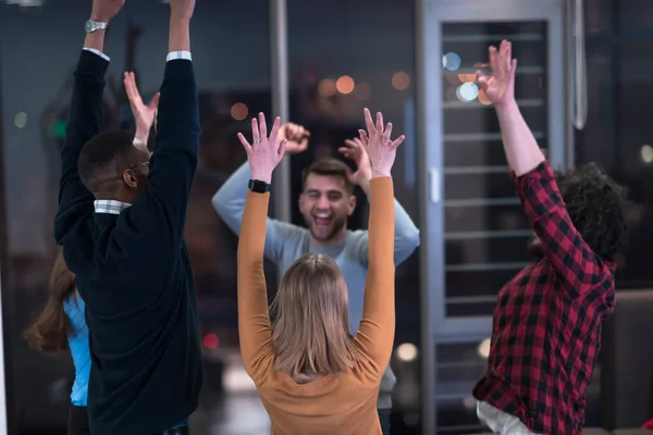 Los jóvenes empresarios multiétnicos se divierten celebrando el éxito empresarial compartido o la victoria en el cargo. Sonrientes empleados multirraciales diversos se sienten emocionados ganar obtener buenos resultados. Concepto de trabajo en equipo. — Foto de Stock