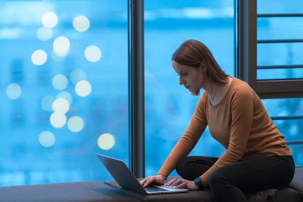 Uma jovem mulher sentada em um espaço moderno enquanto trabalhava em um projeto em um laptop. Foco seletivo — Fotografia de Stock