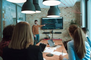 Lider bir ofis konferansında bir iş sunumu yapıyor, iş adamı koçu yönetim kurulundaki şirket grup atölyesi eğitiminde grafik grafiğini açıklıyor. Seçici odak 