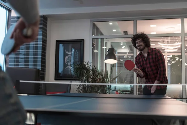 Due giovani start up uomo d'affari che giocano a ping pong nel moderno spazio creativo ufficio gruppo di persone hanno riunione e brainstorming in background — Foto Stock