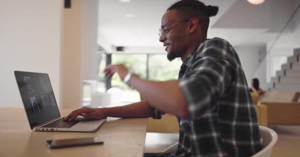 アフリカ系アメリカ人ビジネスマンがスマートフォンやノートパソコンを使ってオンライン会議ビデオ通話を行う。男性コールセンターエージェント,現代のホームオフィスでの距離ウェブカメラ会議を持つマネージャー — ストック動画