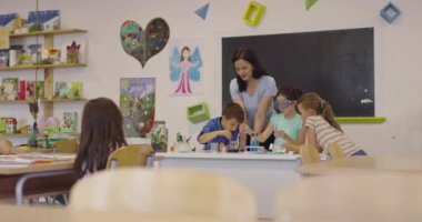 İlköğretim Okulu Bilim Sınıfı: Coşkulu Öğretmen Kimyayı Çeşitli Çocuklar Grubu 'na Açıkladı, Küçük Çocuk Kimyasalları Beakers' a Karıştırdı. Çocuklar Faiziyle Öğrenin