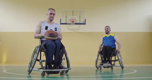Tekerlekli sandalyeli iki arkadaş modern bir salonda maçın başlamasını bekliyorlar. — Stok video