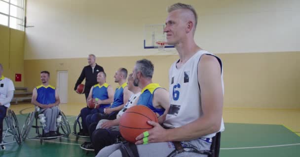 Volič Vysvětluji novou taktiku basketbalovým hráčům na kolečkových křeslech, osobám se zdravotním postižením sedí na kolečkových křeslech a poslouchají voliče — Stock video