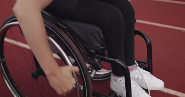 Antrenman pistinde tekerlekli sandalyeye mahkum bir kadın. — Stok video