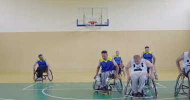 Engelli insanlar modern salonda basketbol oynarlar.