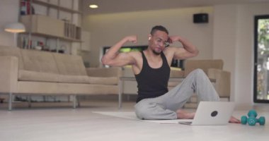Coronavirus salgını sırasında müşteriyle çevrimiçi eğitim için dizüstü bilgisayar kullanan Afrikalı Amerikalı fitness eğitmeni.