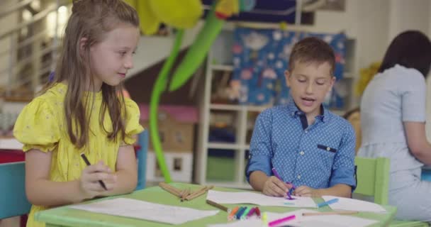 Kreativní děti při výtvarné hodině ve školce nebo na základní škole kreslení s učitelkou. — Stock video