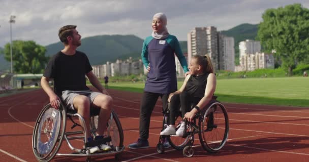 Tiro de personas con discapacidad deportiva whit entrenador femenino usando hijab después de entrenar en pista deportiva de atletismo. — Vídeos de Stock