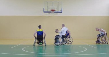 Engelli insanlar modern salonda basketbol oynarlar.