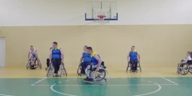 Engelli insanlar modern salonda basketbol oynarlar.