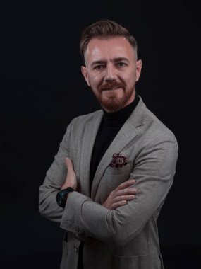 Fotoğraf stüdyosunda sakallı ve sıradan iş kıyafetleri giyen zarif bir kıdemli işadamının portresi. Koyu renk arka planda el kol hareketleriyle izole edilmiş.