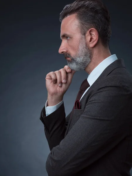 Portrait d'un élégant homme d'affaires élégant avec une barbe et des vêtements d'affaires décontractés dans un studio photo isolé sur fond sombre gesticulant avec les mains — Photo