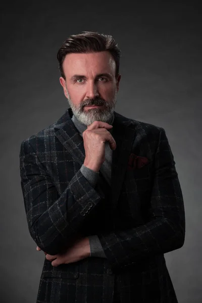 Porträt eines eleganten Geschäftsmannes mit Bart und lässiger Businesskleidung im Fotostudio, isoliert auf dunklem Hintergrund, gestikulierend mit den Händen — Stockfoto