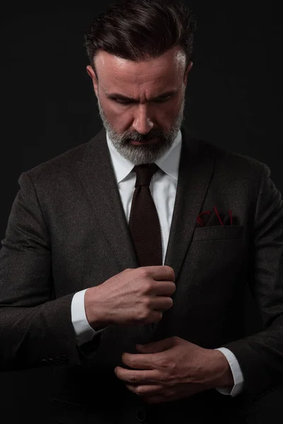 Retrato de un elegante y elegante hombre de negocios con barba y ropa casual de negocios en un estudio de fotografía ajustando el traje — Foto de Stock
