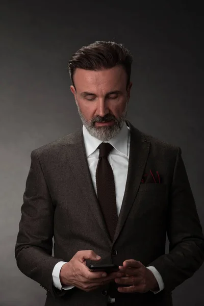 Portrait d'un élégant homme d'affaires élégant avec une barbe et des vêtements d'affaires décontractés dans un studio photo isolé sur fond sombre gesticulant avec les mains — Photo