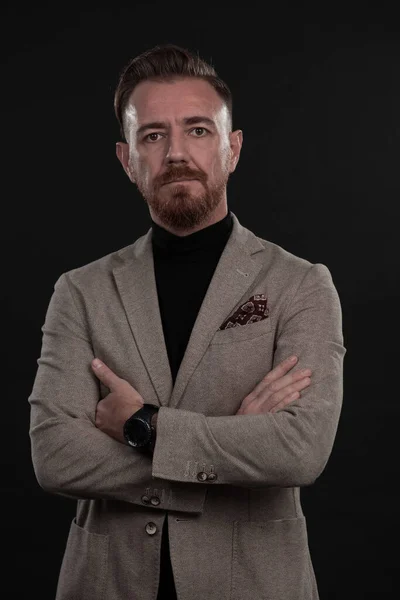 Portrait d'un élégant homme d'affaires élégant avec une barbe et des vêtements d'affaires décontractés dans un studio photo isolé sur fond sombre gesticulant avec les mains — Photo