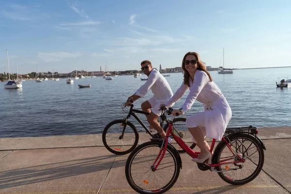 Старша пара насолоджується прекрасним ранком разом, катаючись на велосипеді біля моря. Вибірковий фокус — стокове фото