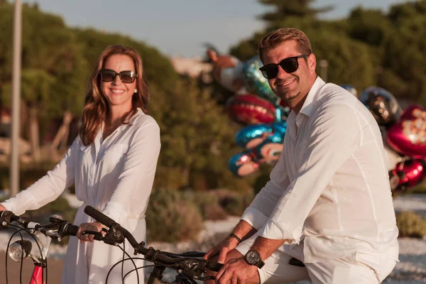 Seniorenpaar genieten van een prachtige ochtend samen rijden op een fiets aan zee. Selectieve focus — Stockfoto