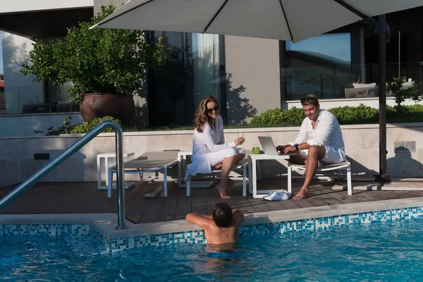 Glückliche Familie genießt Urlaub in einem Luxus-Haus mit Pool. Seniorenpaar verbringt Zeit mit seinem Sohn in den Ferien. Selektiver Fokus — Stockfoto