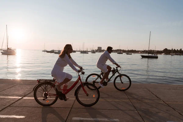 Старшая пара наслаждается прекрасным утром, катаясь на велосипеде у моря. Селективный фокус — стоковое фото