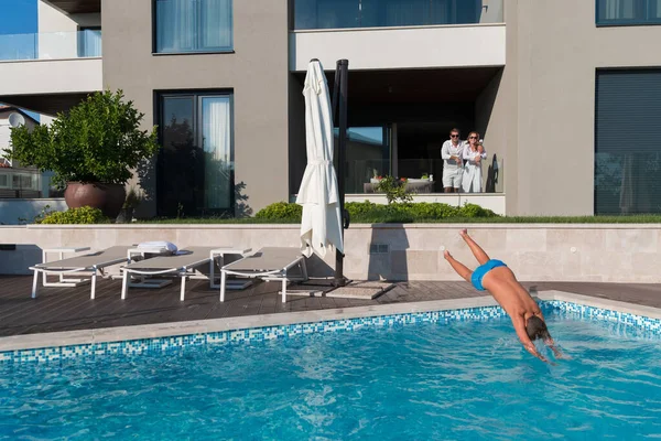 Glückliche Familie genießt Urlaub in einem Luxus-Haus mit Pool. Seniorenpaar verbringt Zeit mit seinem Sohn in den Ferien. Selektiver Fokus — Stockfoto