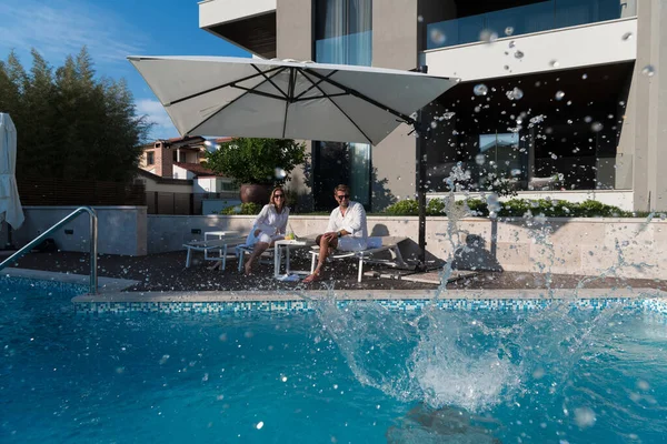 Happy family enjoys vacation in a luxury house with pool. Senior couple spends time with their son during the vacation. Selective focus — Stock Photo, Image