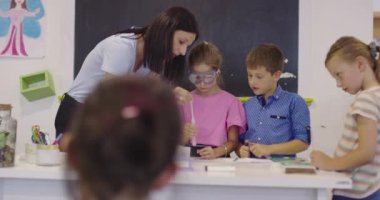 İlköğretim Okulu Bilim Sınıfı: Coşkulu Öğretmen Kimyayı Çeşitli Çocuklar Grubu 'na Açıkladı, Küçük Çocuk Kimyasalları Beakers' a Karıştırdı. Çocuklar Faiziyle Öğrenin