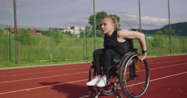 Kobieta niepełnosprawna na wózku inwalidzkim na torze treningowym — Wideo stockowe