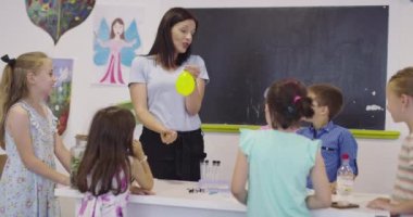 4K, öğrenciler fen dersinde öğretmenlerinin gözetimi altında deney yapıyorlar. Yavaş çekim.