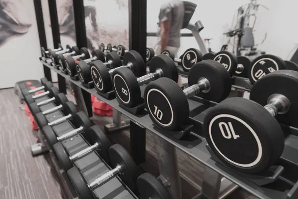 Closeup of kilogram dumbbells placed on a dumbbell rack at the gym. Weight training equipment. — Stock Photo, Image