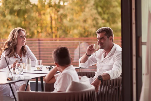 Um casal de idosos desfruta do terraço de uma casa de luxo com seu filho durante as férias. Foco seletivo — Fotografia de Stock