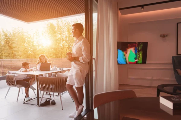 Una pareja de ancianos disfruta de la terraza de una casa de lujo con su hijo durante las vacaciones. Enfoque selectivo —  Fotos de Stock