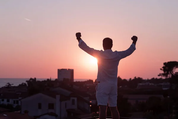 Літній бізнесмен в повсякденному одязі насолоджується дахом свого будинку під час заходу сонця. Вибірковий фокус — стокове фото