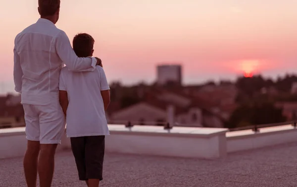 Père et fils passent du temps ensemble sur le toit de la maison tout en profitant du coucher de soleil. Concentration sélective — Photo