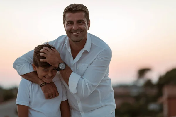 Baba ve oğul gün batımının tadını çıkarırken evin çatısında birlikte vakit geçiriyorlar. Seçici odak — Stok fotoğraf