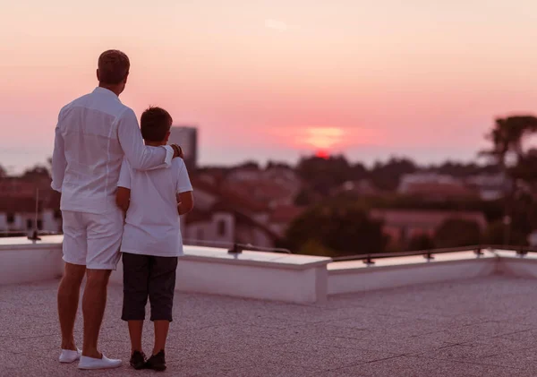 Père et fils passent du temps ensemble sur le toit de la maison tout en profitant du coucher de soleil. Concentration sélective — Photo