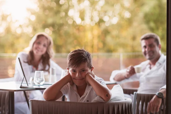 Una pareja de ancianos disfruta de la terraza de una casa de lujo con su hijo durante las vacaciones. Enfoque selectivo —  Fotos de Stock