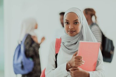 Geleneksel İslami tesettüre bürünmüş bir grup arkadaşı olan Afrikalı bir kız öğrenci. Odaklanma seç 