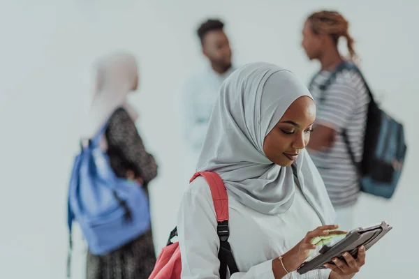 Africká studentka se skupinou přátel v pozadí nosí tradiční islámské hidžáb oblečení. Vybrat zaměření — Stock fotografie