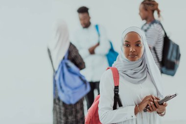 Geleneksel İslami tesettüre bürünmüş bir grup arkadaşı olan Afrikalı bir kız öğrenci. Odaklanma seç 