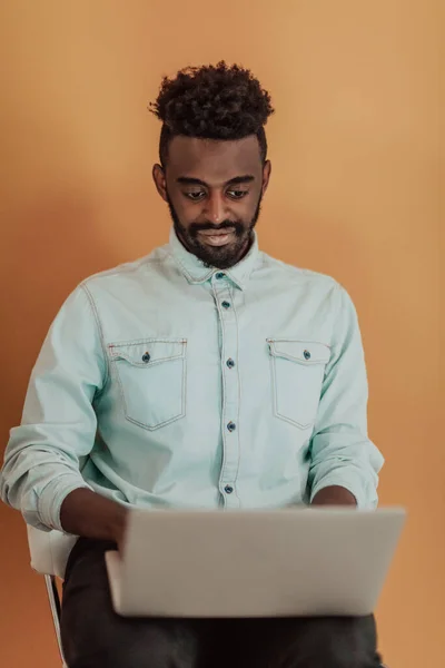 Estudiante africano usando computadora portátil para estudiar y hacer conexiones de negocios fondo amarillo —  Fotos de Stock