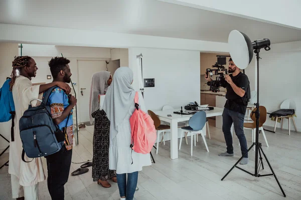 A videographer in a home studio captures a group of modern students with a professional camera. — Stock Photo, Image