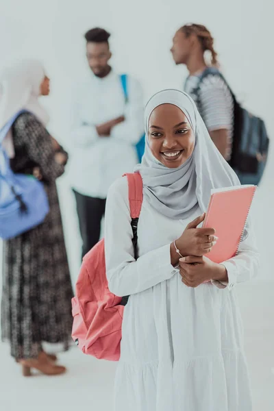 전통 이슬람 히잡 옷을 입은 아프리카 여학생들 이 배경에 친구들 과 함께 있습니다. 선택 초점 — 스톡 사진