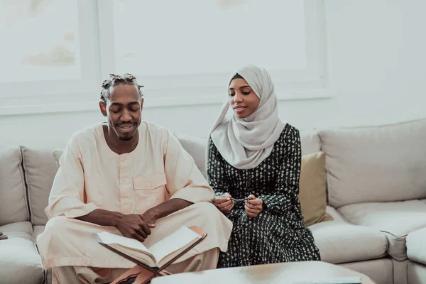 Pasangan muslim Afrika di rumah dalam ramadan membaca buku quran holly islam. — Stok Foto