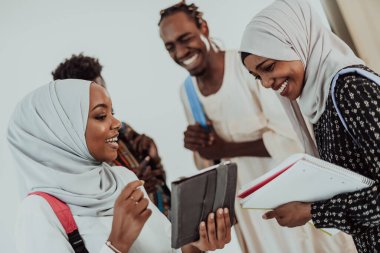 Geleneksel İslami tesettüre bürünmüş bir grup arkadaşı olan Afrikalı bir kız öğrenci. Odaklanma seç 