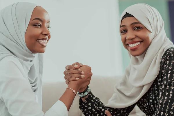 アフリカの女性の腕レスリング紛争の概念は、意見の相違や対立は、伝統的なイスラムヒジャーブの服を着て。選択的焦点 — ストック写真