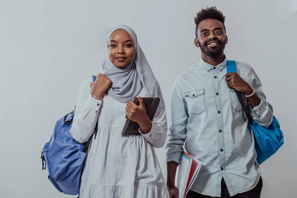 Mladí afričtí studenti pár chodící žena na sobě tradiční súdánské muslimské hidžáb oblečení obchodní tým izolovaný na bílém pozadí. Kvalitní fotografie — Stock fotografie