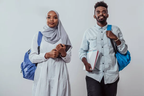 Unga afrikanska studenter par promenader kvinna bär traditionella Sudan muslimska hijab kläder affärsteam isolerad på vit bakgrund. Högkvalitativt foto — Stockfoto